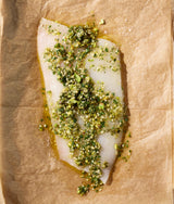 Raw fish fillet with marinade on brown paper.